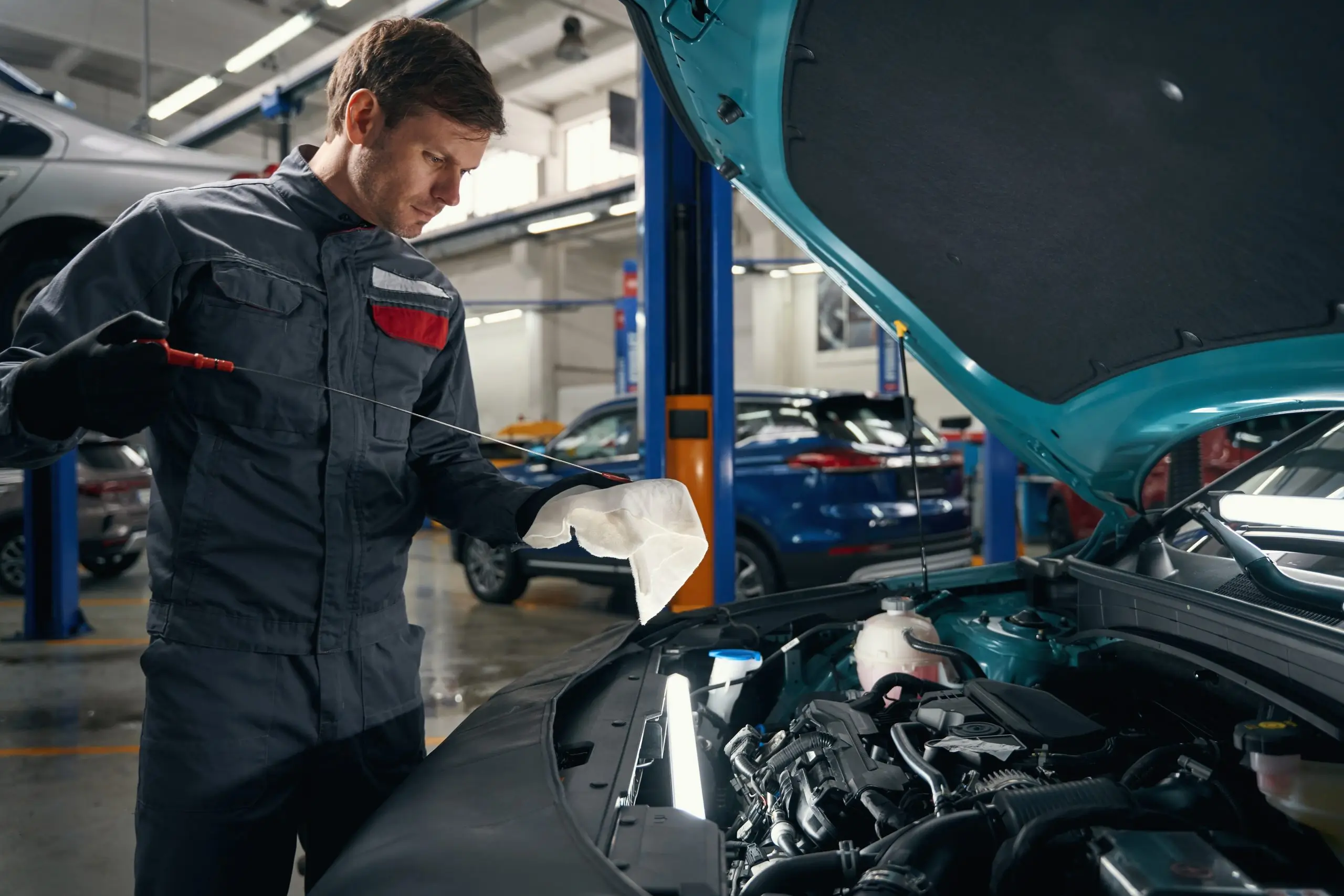 Technician conducting oil change and inspection as part of regular preventive car maintenance.