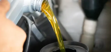Pouring engine oil to car engine. Fresh oil poured during an oil change to a car.